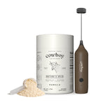 Cowboy Colostrum Vanilla bottle and frother with loose powder on white background